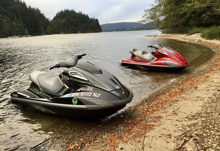 Black and Red Jet Ski's sitting on the side of Lake Whatcom.